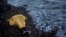FILE - Plastic sheeting covers the body of an unidentified boy near Skala, a village on the Greek island of Lesbos, Nov. 1, 2015. He was among nearly 4,000 to die in attempted Mediterranean crossings this year. 