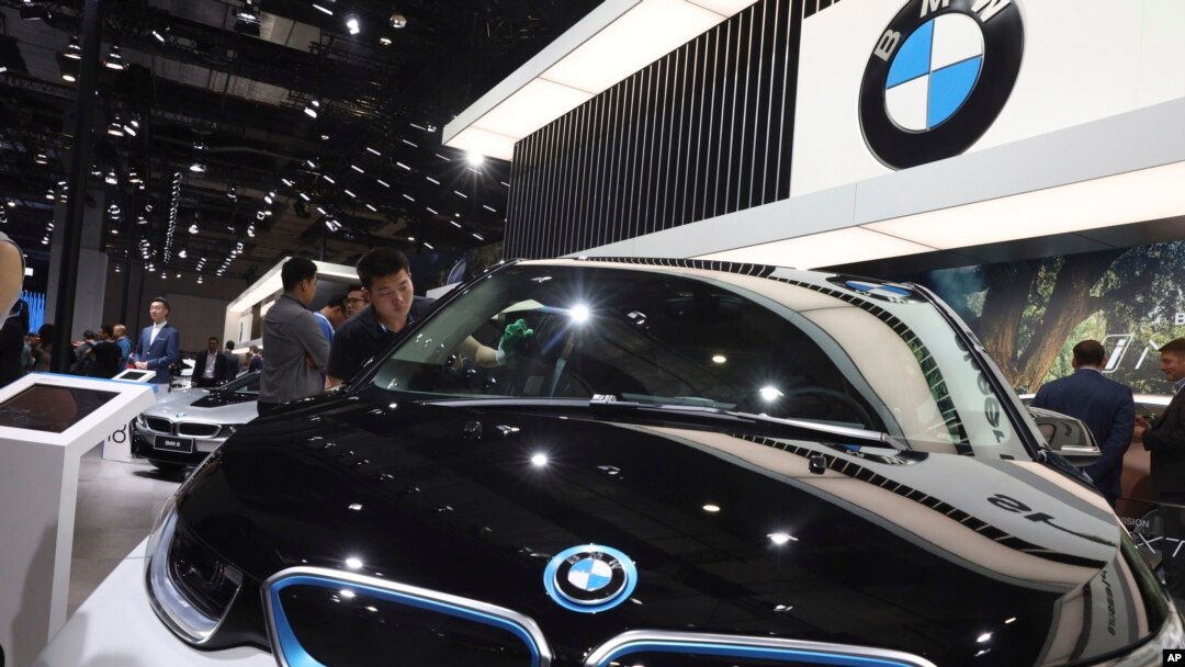 Seorang pekerja tengah membersihkan kendaraan listrik di stand BMW dalam pameran otomotif "Auto Shanghai 2019" di Shanghai, 17 April 2019. (AP Photo/Ng Han Guan, file)