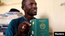 FILE - Abdul Giwa holds a copy of his passport during an interview with Reuters on the recent pronouncements of the Kaduna State government on the activity of the Shi'ite group in Kaduna, Nigeria Nov. 2, 2016. Nigeria has advised its citizens against any non-urgent travel to the United States until Washington clarifies its immigration policy.