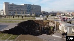 A aerial view shows a sinkhole in the Ospedale del Mare hospital car park, where people come for Covid-19 testing, on the outskirts of the city of Naples, after the ground collapsed early on January 8, 2021, destroying some vehicle.