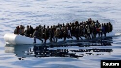 Les migrants a bord d'un canot pneumatique, sauvés par la garde côtière libyenne dans la mer Méditerranée au large des côtes de la Libye, le 15 janvier 2018.