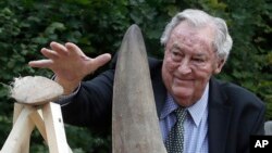 FILE - Richard Leakey, Kenyan wildlife conservationist, places a rhino horn to be burned at the zoo in Dvur Kralove, Czech Republic, Sept. 19, 2017. 