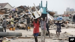 Des enfants transportent des chaises en plastique a Lagos, au Nigeria, 12 novembre 2016