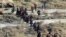 FILE - This Nov. 27, 2016 photo provided by the Rumaf, a Syrian Kurdish activist group, which has been authenticated based on its contents and other AP reporting, shows people fleeing rebel-held eastern neighborhoods of Aleppo into the Sheikh Maqsoud area that is controlled by Kurdish fighters in Syria.