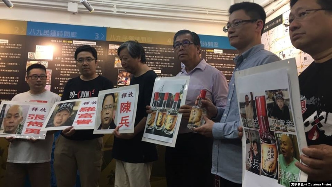 香港支联会2017年2月手举张隽勇、罗富誉和陈兵等人的照片接受陶君行从美国带回的“铭记八酒六四”纪念酒。