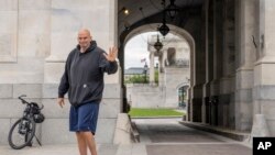 FILE - Sen. John Fetterman, D-Pa., waves to members of the media, Monday, April 17, 2023, on Capitol Hill in Washington.