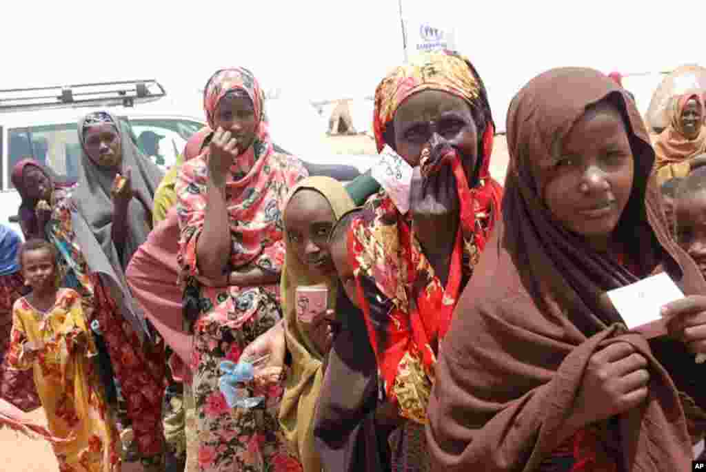 Women line up holding their meal cards outside a feeding center at the Dollo Ado transit camp. VOA - P. Heinlein