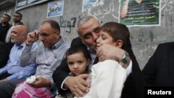 Pemimpin senior Hamas Ismael Haniyeh mencium anak kepala militer Hamas yang tewas dalam serangan udara Israel. (Foto: AP)