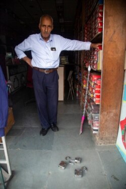 Kashmiri shopkeeper Ghulam Mohideen shows locks of his shop that he said were broken by police in Srinagar, Indian-controlled Kashmir, Aug 5, 2021.