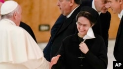 FILE - In this Dec. 23, 2021, file photo, Pope Francis, left, shakes hands with Sister Raffaella Petrini at the Vatican. On Saturday, she was named president of the Vatican City State.