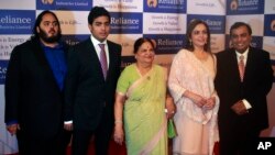 India's largest private sector company, Reliance Industries chairman Mukesh Ambani, right, poses or photographs with his wife Nita Ambani, second right, mother Kokilaben Ambani, center, sons Akash Ambani, second left and Anant Ambani, left during the company's annual general meeting in Mumbai, India.