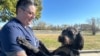 La sargento de la Fuerza Aérea Heather O'Brien sostiene a su perro de asistencia labradoodle, Albus, el jueves 7 de noviembre de 2024, en Kansas City, Kansas. 