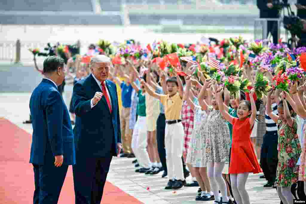在北京人民大会堂东门外广场举行的欢迎仪式上，中国儿童手举鲜花和美中小国旗，欢迎来访的美国总统特朗普。中国国家主席习近平站在特朗普身旁。(2026年5月14日)