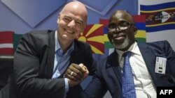 Le président de la FIFA, Gianni Infantino, serre la main du président de la fédération nigériane Amaju Pinnick lors d'une conférence de presse à l'issue du sommet exécutif de la FIFA à Lagos, le 20 février 2018.