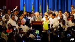 FILE - Sri Lanka's reinstated Prime Minister Ranil Wickeremesinghe, center, surrounded by his loyal lawmakers and supporters speaks after assuming duties in Colombo, Dec. 16,2018.