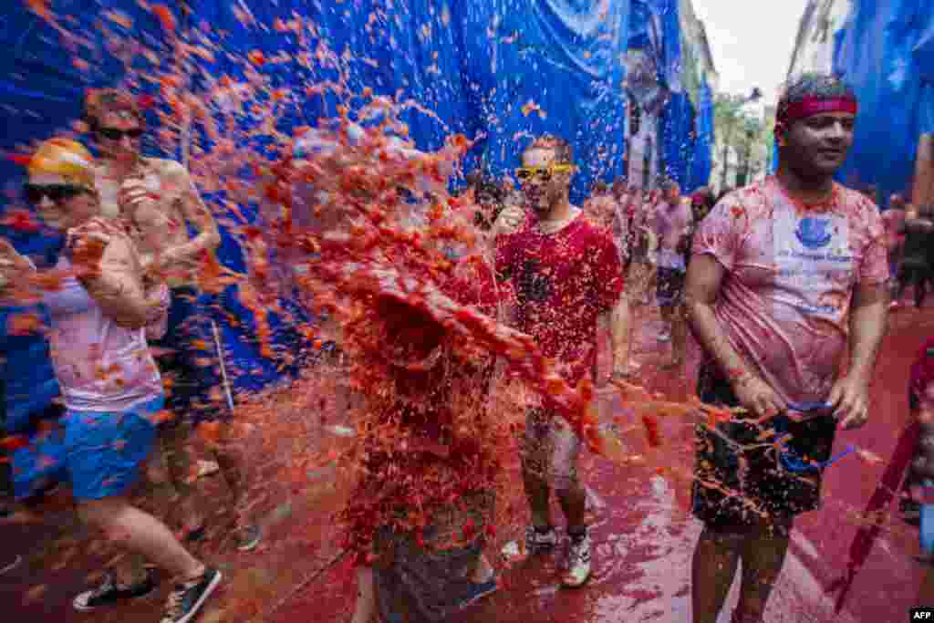 Revelers take part in the annual &quot;Tomatina&quot; festivities in Bunol, near Valencia, Spain. Twenty thousand revelers hurled 130 tons of squashed tomatoes at each other, drenching the streets in red in a gigantic Spanish food fight.