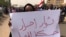 A Sudanese protester holds an Arabic placard that reads: "Free revolutionaries will continue the path," during a demonstration against the military council, in Khartoum, Sudan, June 30, 2019. 