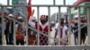 A protester wearing traditional a costume shout slogans and flashes a three-finger sign of resistance during a protest against the military coup in Yangon, Myanmar, Feb. 28, 2021. 