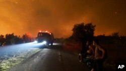 Flames burn a forest during a wildfire in Skepasti village on the island of Evia, about 150 kilometers (93 miles) north of Athens, Greece, Aug. 5, 2021. Wildfires rekindled outside Athens and forced more evacuations around southern Greece.