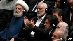 Hamas chief Ismail Haniyeh claps as Iranian President Masoud Pezeshkian speaks while deputy leader of the Lebanese militant group Hezbollah, Sheikh Naim Kassem, left, sits during the swearing-in ceremony of Pezeshkian at the Iranian parliament, in Tehran, Iran, July 30, 2024.