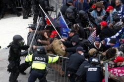 Pro-Trump protesters tear down a barricade as they clash with Capitol Police during a rally to contest the certification of the 2020 U.S. presidential election results by the Congress, at the U.S. Capitol Building in Washington, Jan. 6, 2021.