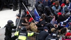 Pro-Trump protesters tear down a barricade as they clash with Capitol Police during a rally to contest the certification of the 2020 U.S. presidential election results by the U.S. Congress, at the U.S. Capitol Building in Washington, Jan. 6, 2021.