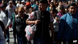 Seorang pria menggunakan tas kain untuk membawa belanjaannya di Mexico City, Rabu, 1 Januari 2020. (Foto: AP)