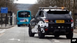 FILE - A self-driving car drives with a safety driver onboard during a demonstration of connected and autonomous cars, on open public roads in Milton Keynes, England, March 22, 2018.