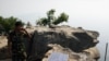 A Cambodian soldier talks on a phone from his position at the 11th-century Preah Vihear temple on the border between Thailand and Cambodia February 9, 2011. Thailand and Cambodia faced growing diplomatic pressure on Wednesday to end an armed standoff on a