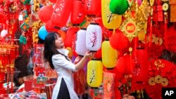 Seorang perempuan melihat-lihat lampion yang dijual di pasar tradisional menjelang perayaan Tahun Baru Imlek atau di Vietnam disebut sebagai "Tet" di kawasan kota tua Hanoi, Vietnam. (Foto: AP)