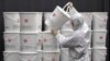 A worker in protective gear stacks plastic buckets containing medical waste from coronavirus patients at a medical center in Daegu, South Korea, Feb. 24, 2020. 