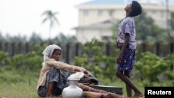 Rohingya Muslims people rest by the road with their belongings as they move from their village after recent violence in Sittwe, June 16, 2012. 