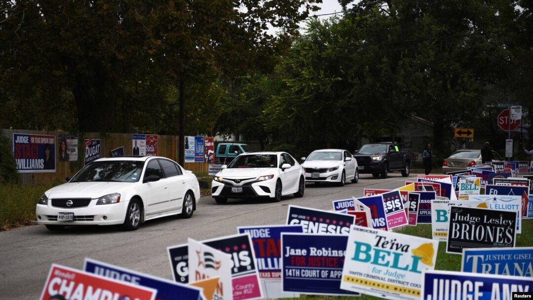 FILE - A line of cars drive in for an event encouraging community members to vote in the upcoming presidential election at an early voting site in Houston, Texas, U.S., Oct. 25, 2020.