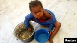 FILE - A Congolese child eats a meal at a UNHCR reception center at the Kyangwali refugee camp, Uganda, March 19, 2018. 