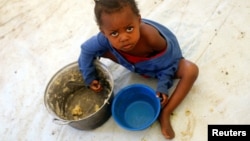 FILE - A Congolese child eats a meal at a UNHCR reception center in the Kyangwali refugee settlement camp, Uganda March 19, 2018. 