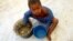 FILE - A Congolese child eats a meal at a UNHCR reception center in the Kyangwali refugee settlement camp, Uganda March 19, 2018. 