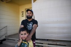 A Barkindji man, hunter and goat musterer Kyle Philip, poses for a photograph with his son Kaleb at their home in Menindee, Australia, Sept. 2, 2019. "The river country itself, it doesn't provide as much as what it used to," said Kyle.