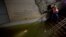 Joseph Leader, Metropolitan Tranportation Authority Vice President and Chief Maintenance Officer, shines a flashlight on standing water inside the South Ferry 1 train station in New York City, Oct. 31, 2012.
