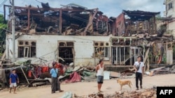 FILE - People inspect destroyed and damaged buildings after bombardments carried out by Myanmar's military in Lashio in Myanmar's northern Shan State on Sept. 24, 2024. 