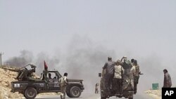 Rebel fighters enter the village of Al-Qawalish after a battle to seize control of the town from forces loyal to Libya's leader Moammar Gadhafi, July 6, 2011