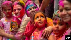 Indians smeared in color participate in Holi festival celebrations in Gauhati, India, March 29, 2021, when Hindus threw colored powder and sprayed water in massive celebrations. Many Indian states restricted to contain a rippling coronavirus resurgence.