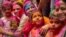 Indians smeared in color participate in Holi festival celebrations in Gauhati, India, March 29, 2021, when Hindus threw colored powder and sprayed water in massive celebrations. Many Indian states restricted to contain a rippling coronavirus resurgence.