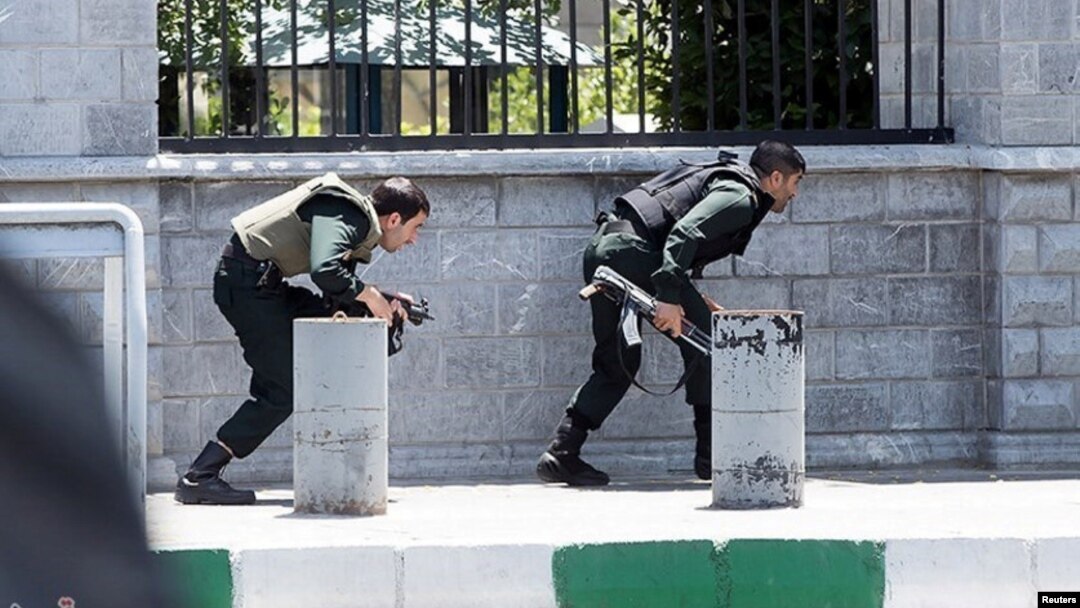 FILE - Members of Iranian forces take cover during an attack on the Iranian parliament in central Tehran, Iran, June 7, 2017. 