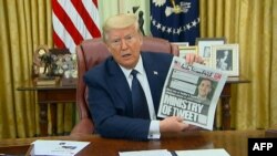 El presidente de los Estados Unidos, Donald Trump, muestra la portada de un diario local que aborda el tema de las redes sociales durante la firma del decreto, el pasado 28 de mayo.