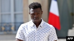 FILE - Mamoudou Gassama, 22, from Mali, leaves the Elysee Palace after his meeting with French President Emmanuel Macron, in Paris, France, May 28, 2018.