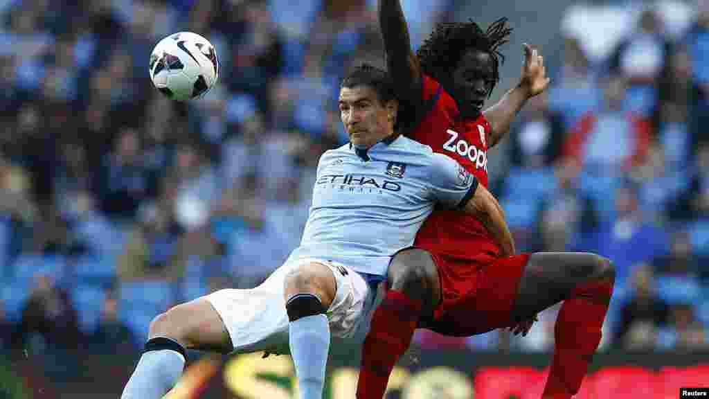 Manchester City's Aleksandar Kolarov (L) challenges West Bromwich Albion's Romelo Lukaku during their English Premier League soccer match at The Etihad Stadium in Manchester, northern England, May 7, 2013. REUTERS/Darren Staples (BRITAIN - Tags: SPORT
