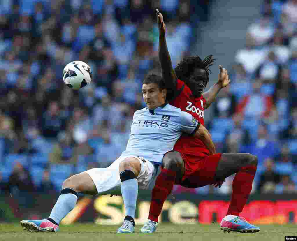 Aleksandar Kolarov do Manchester City (esq.) desafia Romelo Lukaku do West Bromwich Albion durante encontro da Primeira Liga inglesa em Manchester, Inglaterra (7 Maio 2013)