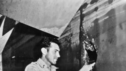 Louis Zamperini shows the hole in his airplane