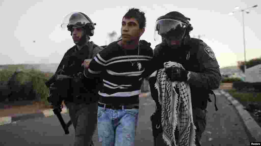 Israeli policemen detain an Arab youth during clashes at the entrance to the town of Kfar Kanna, Israel, Nov. 8, 2014. 