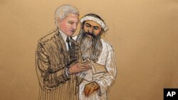In this photo of a sketch by courtroom artist Janet Hamlin and reviewed by the U.S. Department of Defense, Khalid Sheikh Mohammed consults with his civilian attorney David Nevin during a break of his military hearing at the Guantanamo Bay U.S. Naval Base 